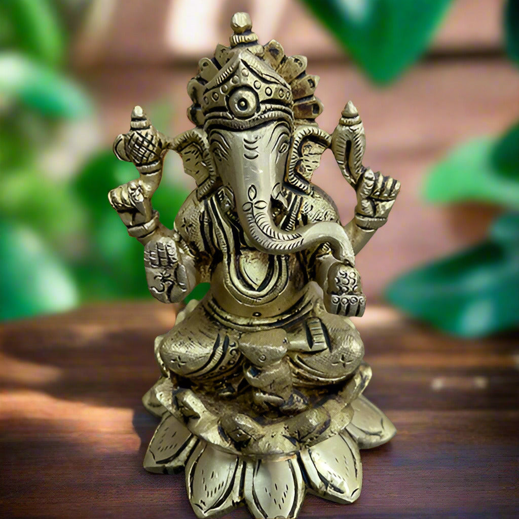 Brass statue of a deity on a dark surface with a light wooden background