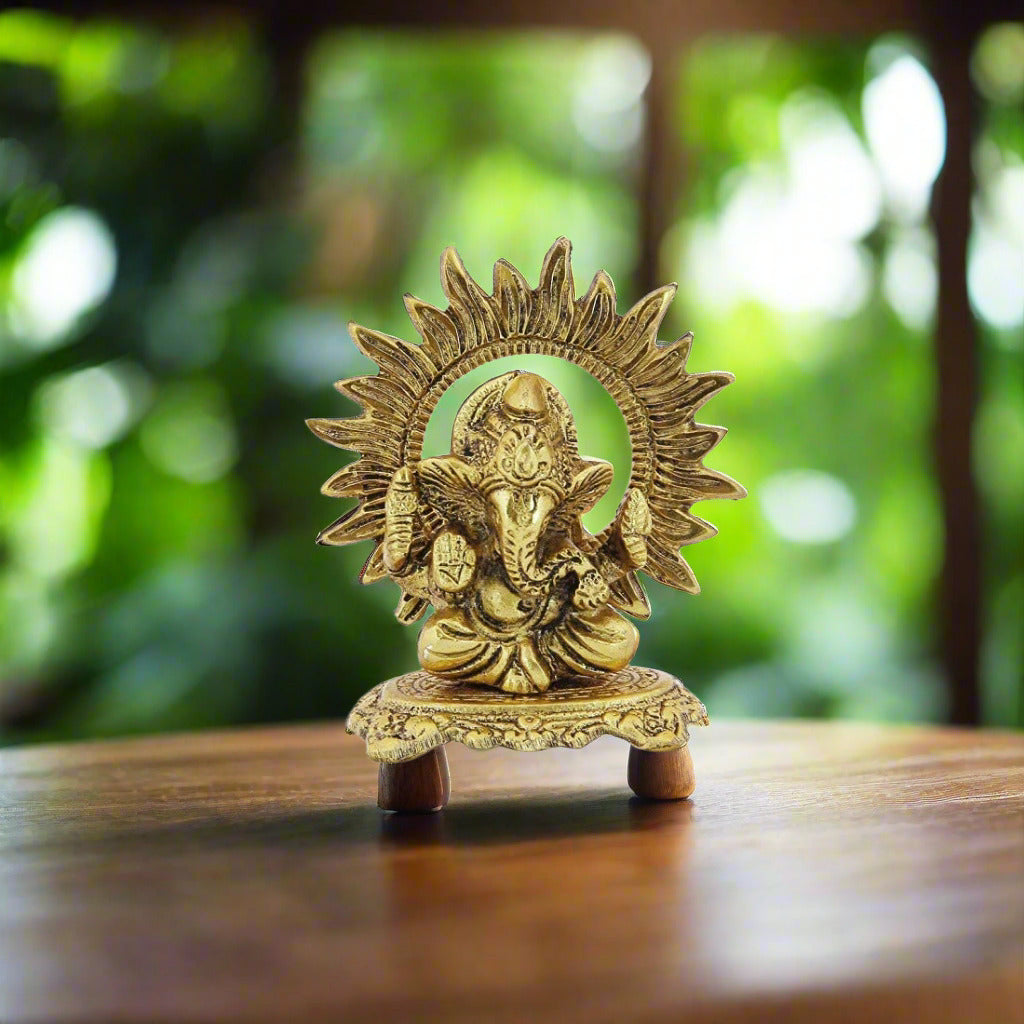 Gold-colored statue of a deity with a sun-like halo on a white background