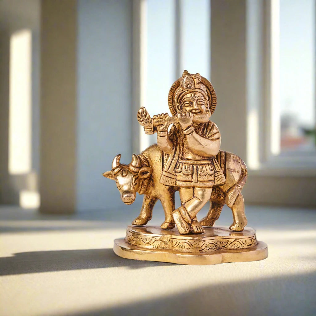 Gold statue of a deity on a bull with a plant in the background